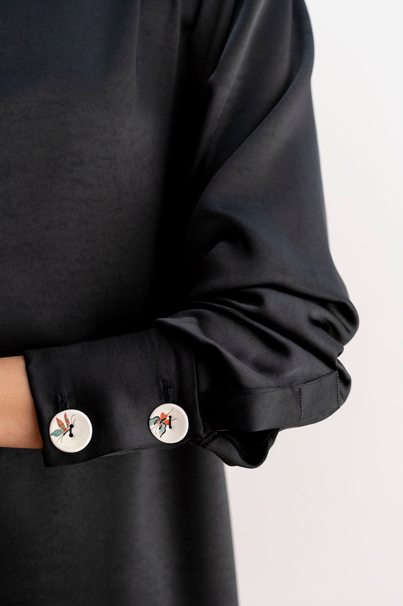 Detalle de los botones del vestido midi asimétrico color negro