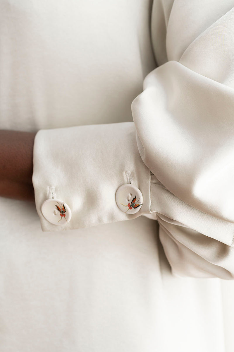 Detalle botones del vestido de noche asimétrico color blanco roto